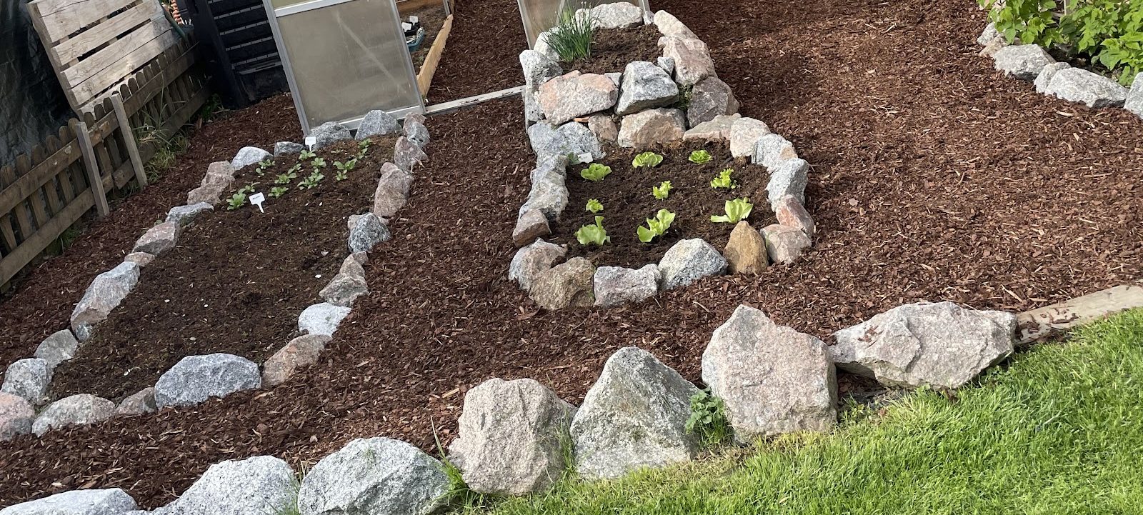 Beete mit Natursteinkante, Mulch und Gewächshaus